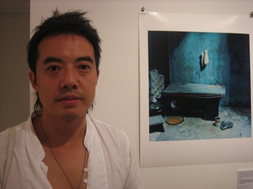 Dinu Li standing next to his artwork
